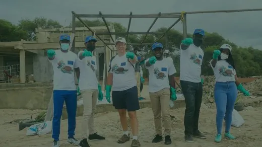 Relawan bersarung tangan hijau berfoto bersama setelah membersihkan sampah di pantai
